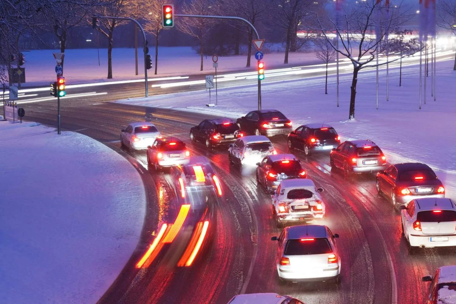 Image shows bunch of automobiles on a slippery road with Snow
