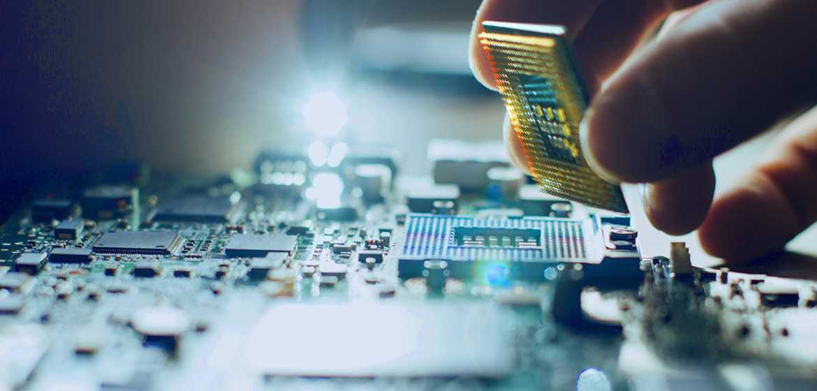 A hand installing a cpu on a motherboard, highlighted by blue and warm lighting, emphasizing advanced technology and precision.